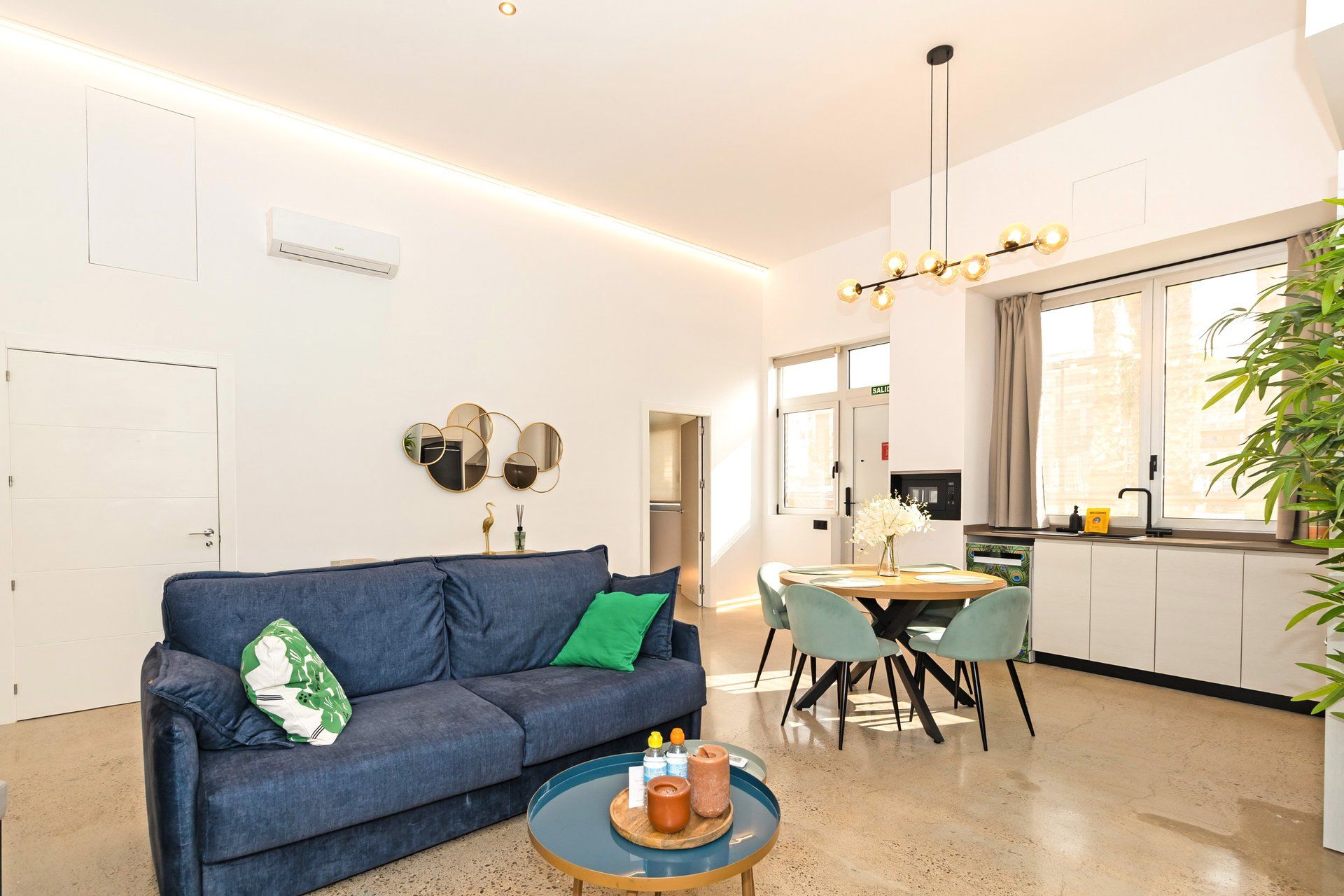 Una sala de estar moderna con un sofá, una mesa de centro y un comedor con sillas y una mesa.