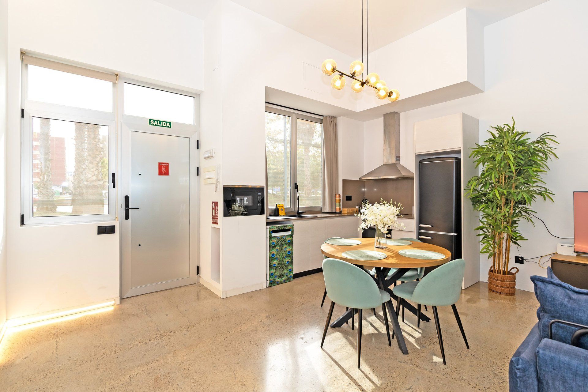 Una cocina moderna con comedor, un refrigerador y un amplio ventanal.