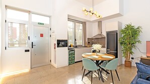 Una cucina moderna con zona pranzo, frigorifero e un'ampia finestra.