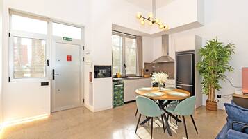Una cocina moderna con comedor, un refrigerador y un amplio ventanal.