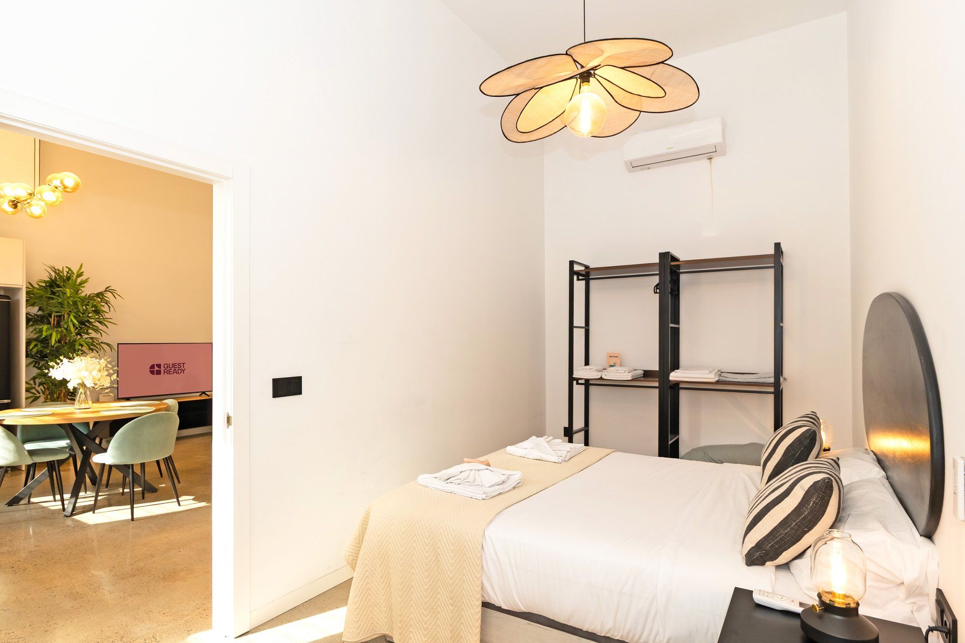 Una habitación de hotel con cama, mesita de noche y zona de escritorio con sillas.