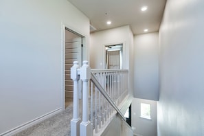 A staircase with white balusters and a handrail leading to an upper level. - Holiday Hideaway Retreat 3BDRM/2BA (San Angelo)