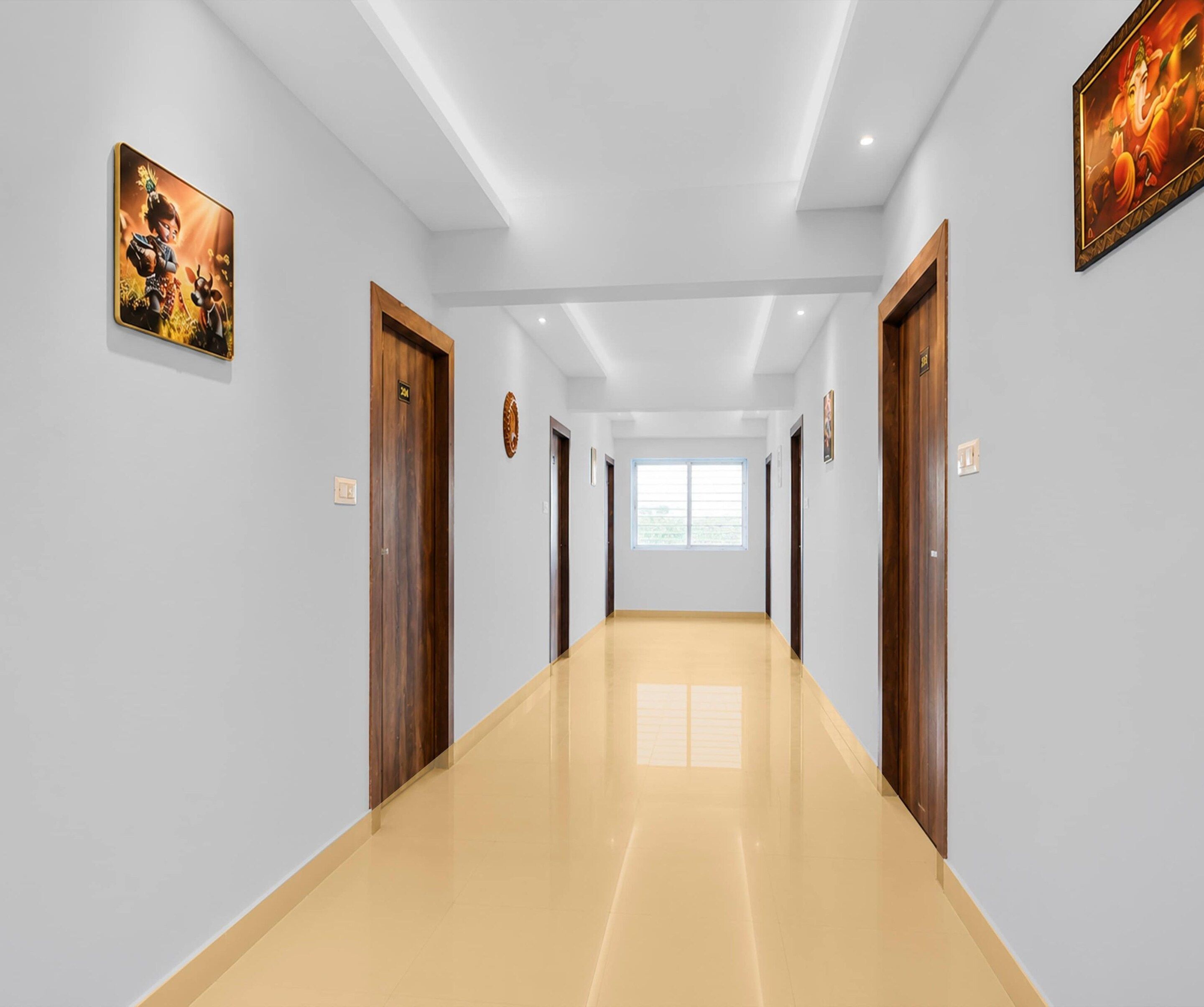 Ein Flur mit Holztüren, Fliesenboden und an der Wand befestigter Kunst.