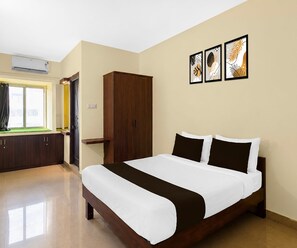 A hotel room with a bed, wardrobe, and artwork on the wall. - Classic Hotel Naina Luxury Rooms (Hyderabad)
