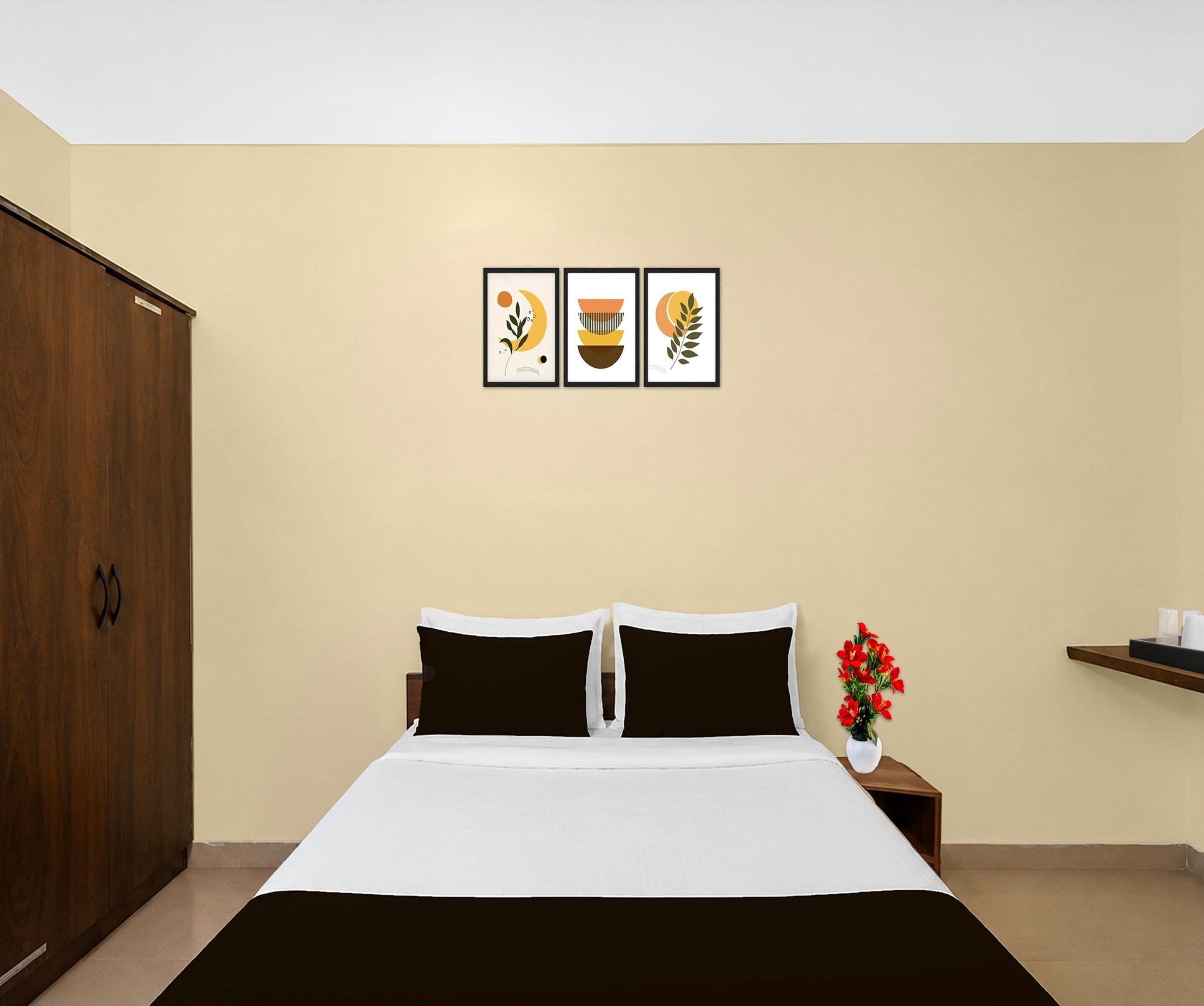 Un dormitorio con una cama, un armario y tres cuadros en la pared.
