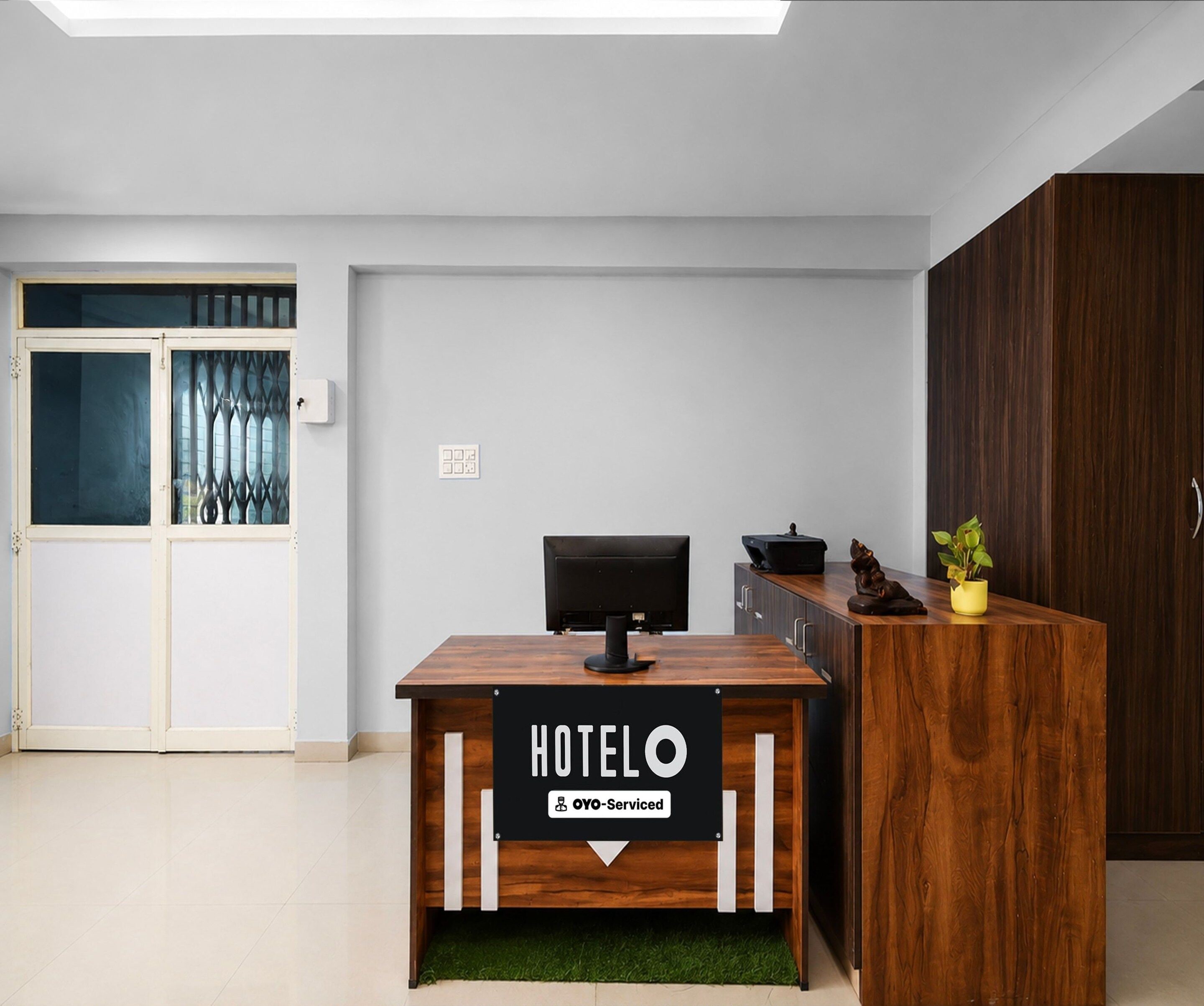A hotel reception desk with a sign indicating it is serviced by OYO.