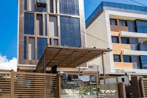 A modern building with a flat facade, large windows, and a visible entrance with a metal gate. - Comfort w/ Balcony in Condo. w/ Pool Fls0306 (João Pessoa)