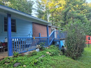 A blue house with a brick section, a blue staircase, and a garden area. - Private, peaceful home near VT, AT, fishing, rafting and spectacular waterfalls (Narrows)