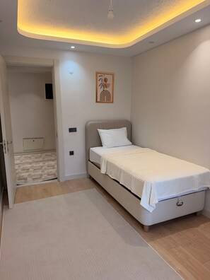 A bedroom with a bed, a door leading to a bathroom, and a ceiling light fixture. - BIO RESIDENCE 3bedroom apartment with AC close to Istanbul Airport. Daily,Weekly (ISTANBUL)