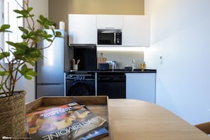 Una cucina moderna con lavastoviglie, forno a microonde e un tagliere di legno sul piano di lavoro.