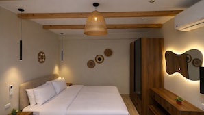 A bedroom with a bed, bedside tables, a hanging light fixture, a wall-mounted mirror, and a built-in wardrobe. - Pyramids Height Luxury Wing (Giza Governorate)