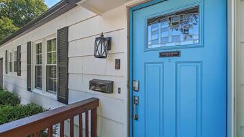 A house with a blue front door, a mailbox, and a window with shutters.