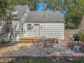 A house with a patio area featuring a grill and outdoor furniture. - Charming 4 BDRM New Listing in OP! (Overland Park)