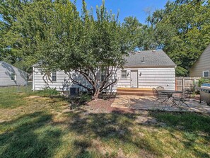 A residential property with a detached house, a covered patio, and a lawn. - Charming 4 BDRM New Listing in OP! (Overland Park)
