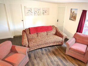 A living room with a patterned sofa, two striped armchairs, and a red throw. - Cozy Retreat - Nature Views - 5 Min to Sewanee (Sewanee)
