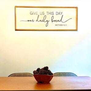 A framed inspirational quote on a wall, a wooden table with a bowl of pinecones, and a chair. - Cozy Retreat - Nature Views - 5 Min to Sewanee (Sewanee)