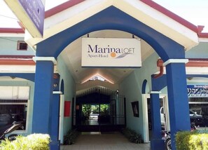 The entrance of a Marina Loft Apart-Hotel with a covered walkway and a sign above the entrance. - Marina Loft Unit 201, 2 Floor (Sardinal)