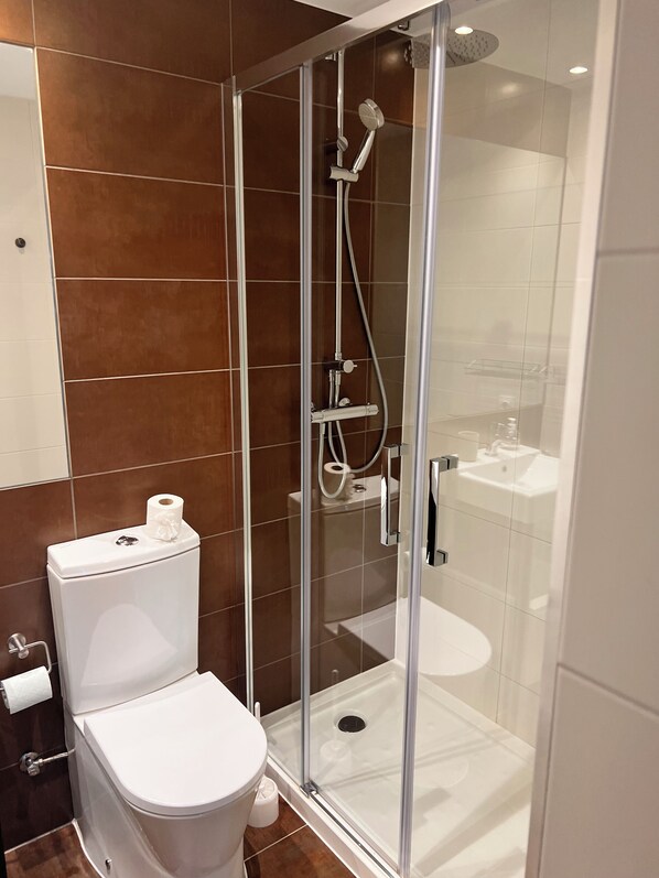 A modern bathroom with a glass-enclosed shower, a white toilet, and a visible sink. - Arenal Beach, Bol, Calpe Lookout (Calpe)