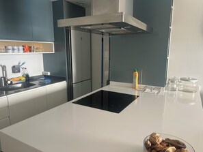A modern kitchen with a stainless steel refrigerator, a built-in oven, and a white countertop. - Arenal Beach, Bol, Calpe Lookout (Calpe)