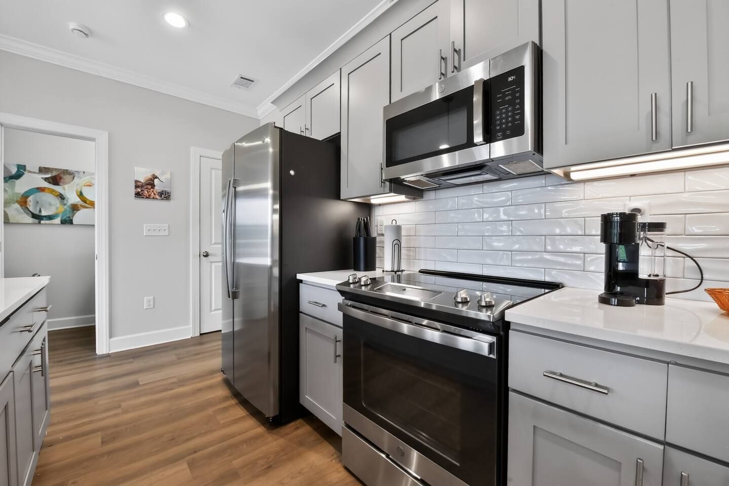 A modern kitchen with stainless steel appliances, a microwave, and a coffee maker.