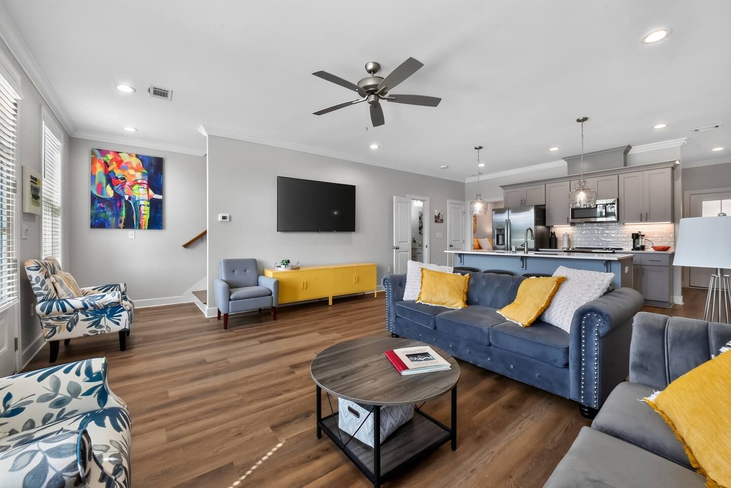 A modern living room with a sofa, armchairs, a coffee table, and a television.