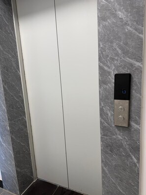 Un ascenseur moderne doté d’un écran numérique et de boutons de commande.