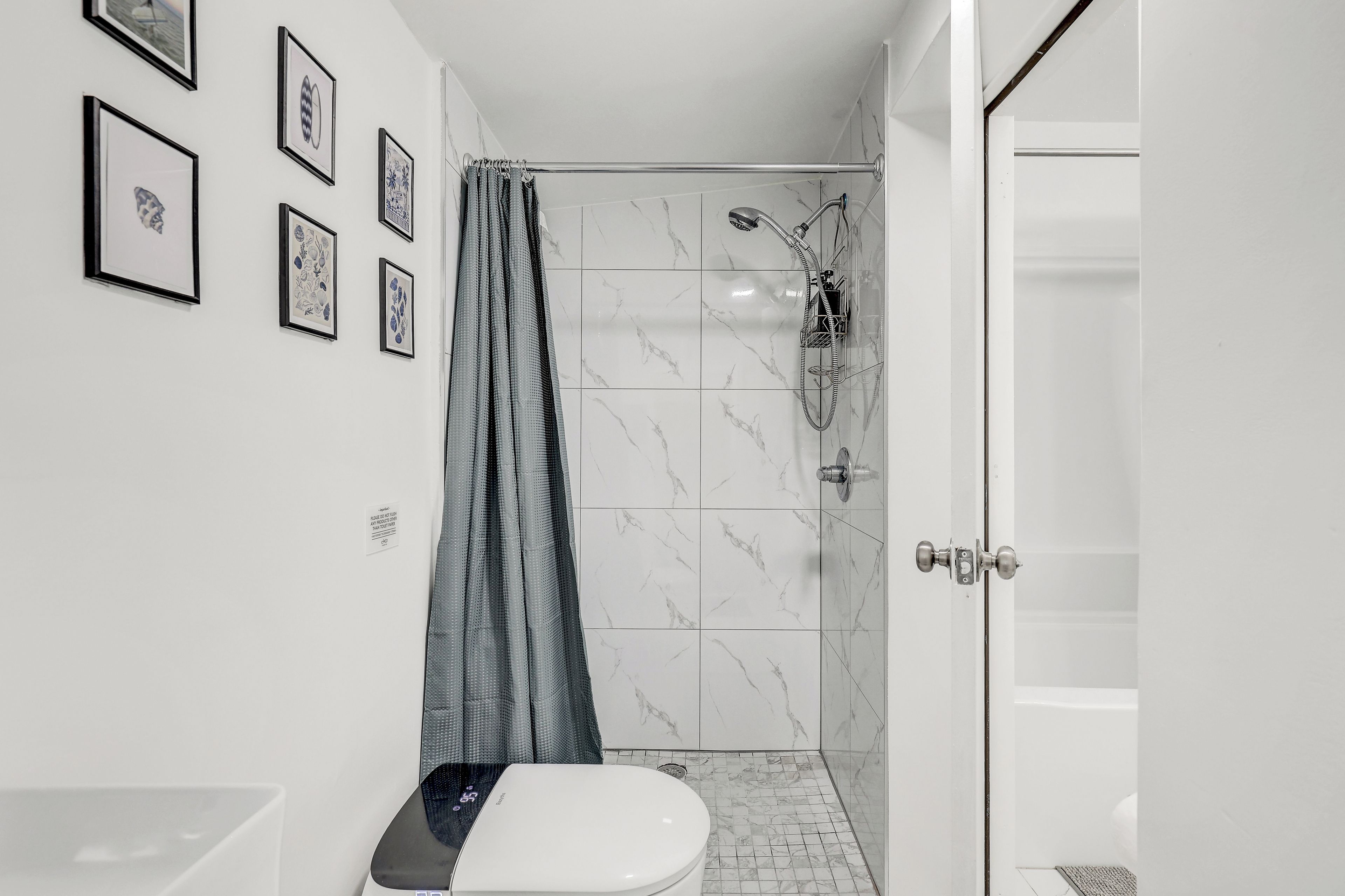 A bathroom with a shower, toilet, and sink.