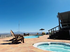 A rooftop pool area with lounge chairs, a hot tub, and a view of distant mountains. - Spacious 5-bedroom house and Casita with endless views of the Temecula Valley (Temecula)