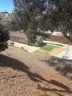 A house with a fenced yard, a paved driveway, and a small lawn area. - Spacious 5-bedroom house and Casita with endless views of the Temecula Valley (Temecula)