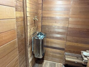 A small, narrow bathroom with wooden paneling on the walls and a metal trash bin. - Spacious 5-bedroom house and Casita with endless views of the Temecula Valley (Temecula)