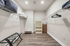 A narrow hallway with a built-in closet, a bench, and a drying rack. - Come & Sea by Stay on 30a (Inlet Beach)