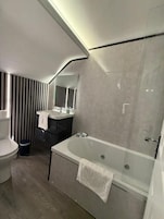 Un baño moderno con bañera, inodoro y tocador.