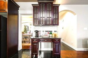 A kitchen with dark wooden cabinets, a central island, and a dining area visible in the background. - CozyHouse*5BR*FamilyBaby&KidFriendly*KingBed*A/C* (Edmonton)