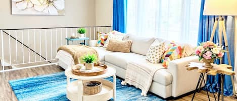 A modern living room with a sofa, coffee table, and a lamp.