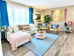 A modern living room with a sofa, armchairs, a coffee table, and a TV. - Family Baby&Kid Friendly*Close toUofA*Kingbed*3BR* (Edmonton)