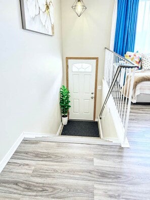 A staircase with a wooden handrail leading to a white door with a glass panel. - Family Baby&Kid Friendly*Close toUofA*Kingbed*3BR* (Edmonton)