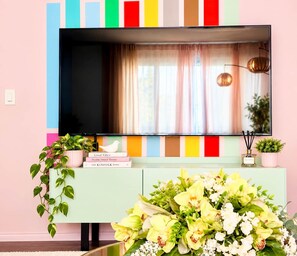 A television mounted on a wall with a colorful striped panel below. - Funky family-friendly 3BR, king bed near U of A (Edmonton)