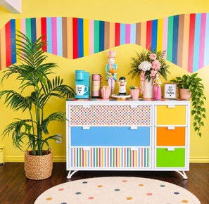 A brightly colored room with a white cabinet, a potted plant, a striped wall, and a polka-dotted rug. - Funky family-friendly 3BR, king bed near U of A (Edmonton)