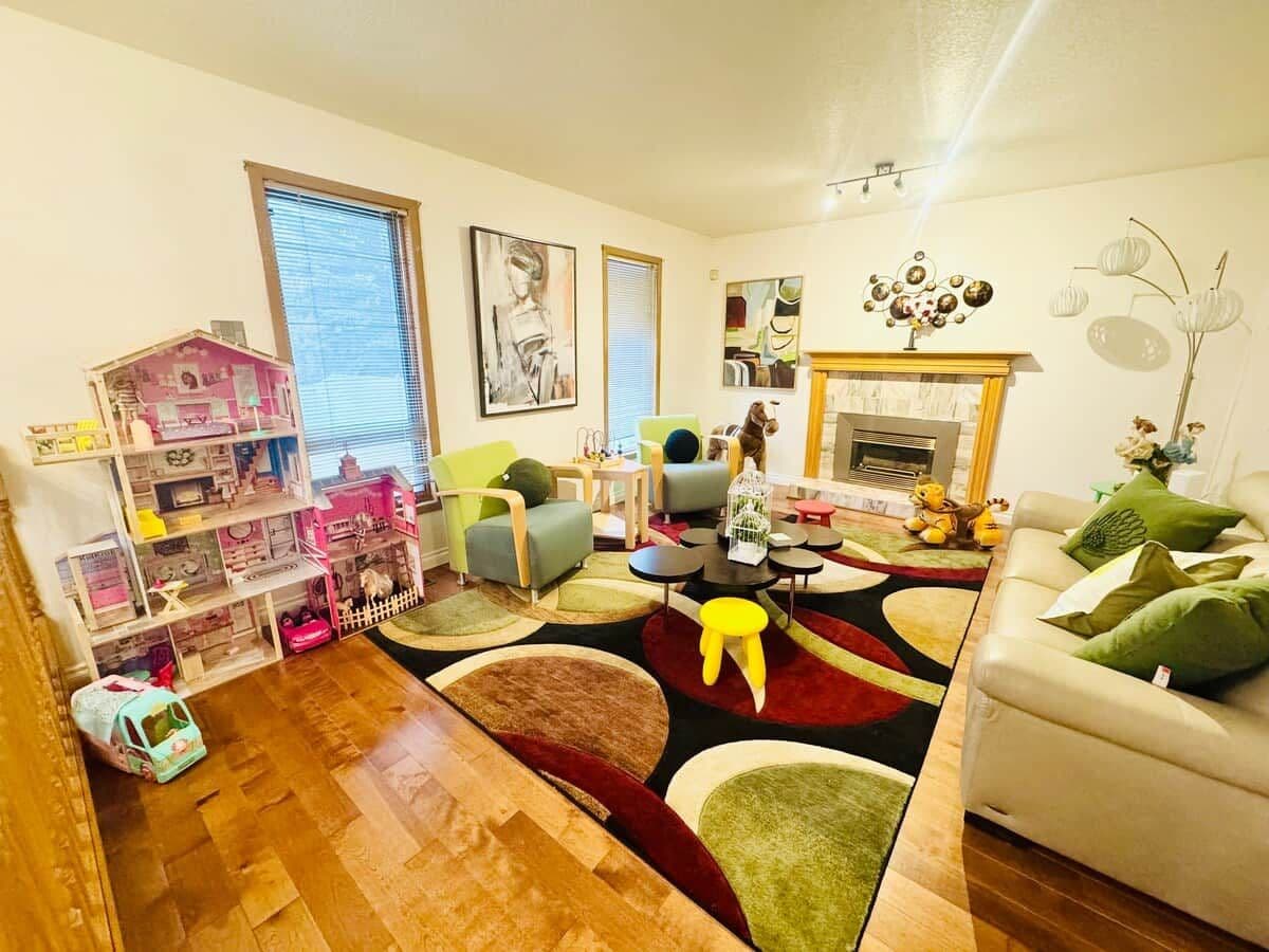 Un salon avec un plancher en bois, un canapé, une table basse et une bibliothèque.