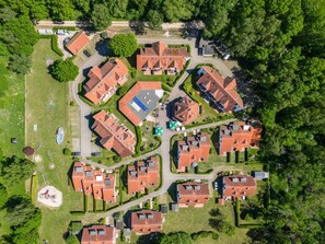 An aerial view of a residential area with multiple houses, a playground, and a sports field. - 1.6/t1 Holiday Home Park \"freesenbruch\" (Zingst)