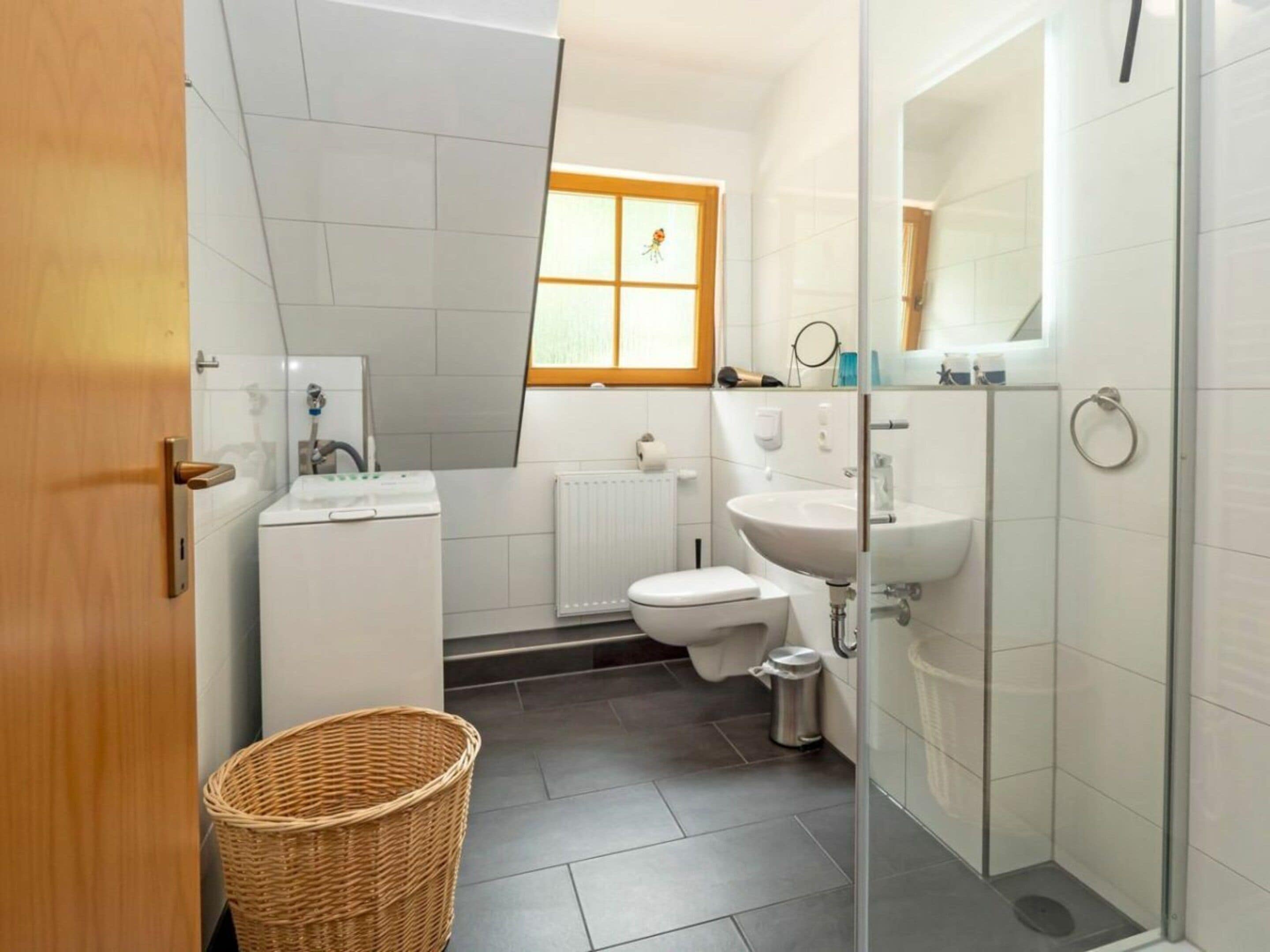 A modern bathroom with a toilet, sink, and shower area.