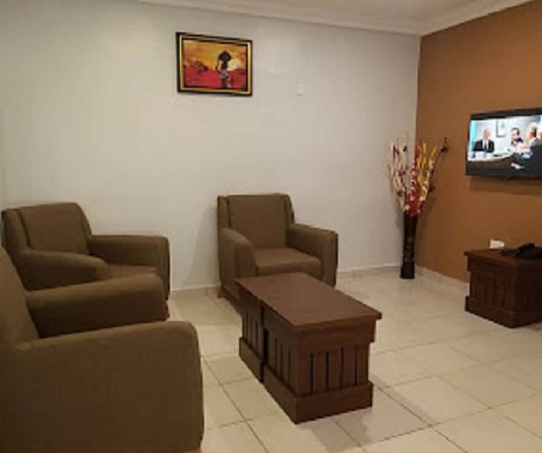Un salon avec deux canapés, une table basse, un téléviseur et un tableau accroché au mur.