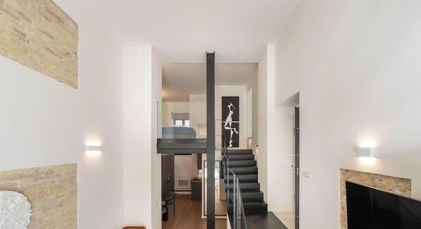 Ein modernes Interieur mit Treppe, Kamin und Wandkunst.