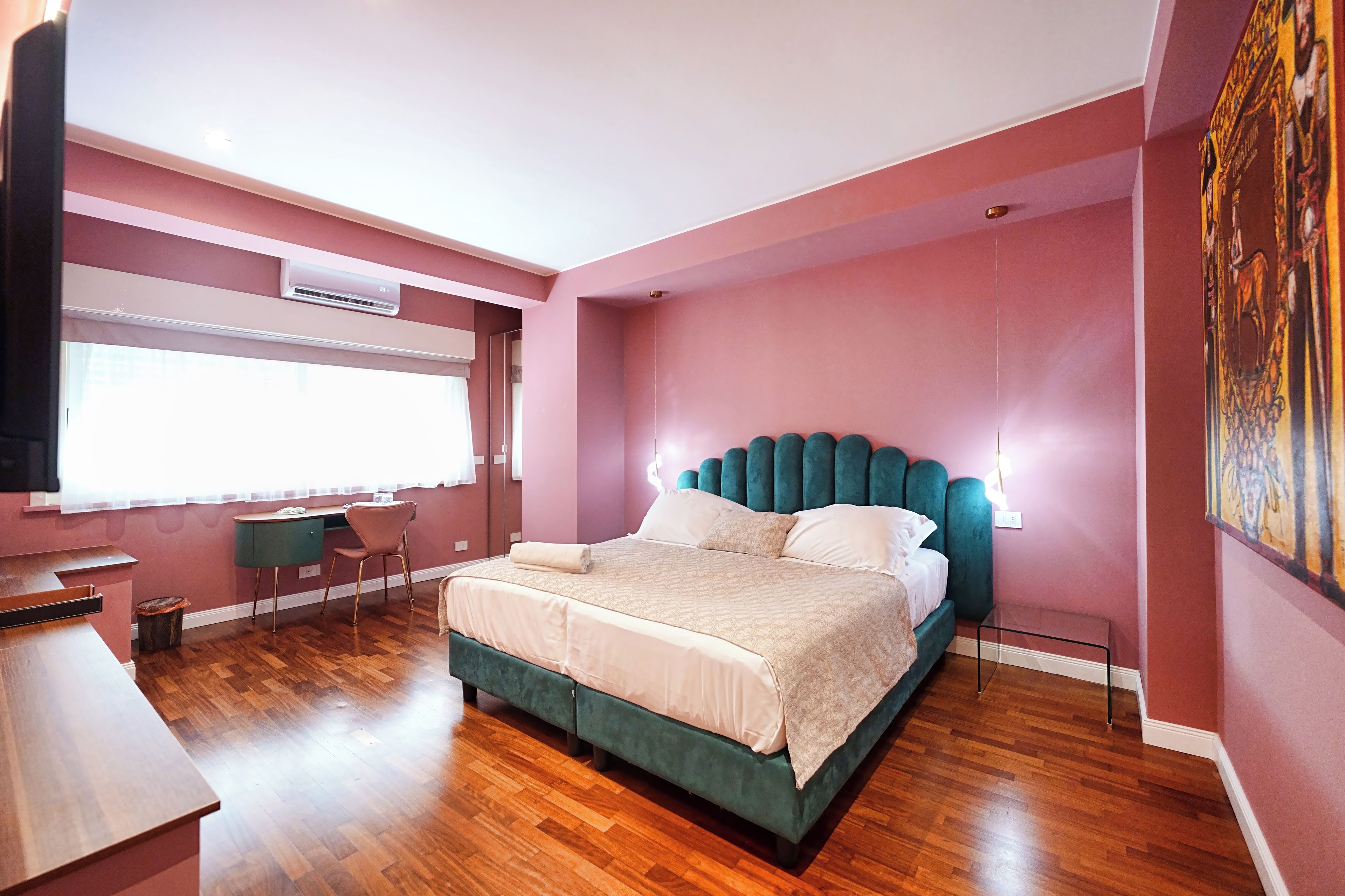 A modern bedroom with a large bed, a desk, and a chair.
