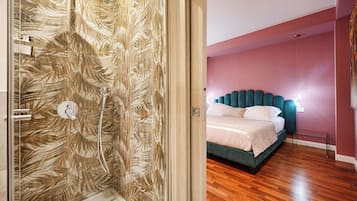 Ein Schlafzimmer mit einem Bett, einer Duschkabine mit Glastür und Holzboden.
