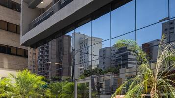 Un bâtiment moderne doté de nombreux balcons et d’une façade en verre réfléchissant.