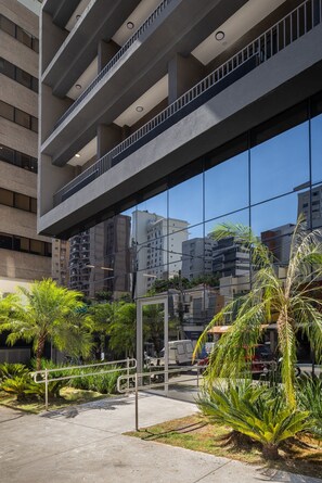 A modern building with multiple balconies and a reflective glass facade. - New Studio in Jardins | 2 Blocks from Paulista | Pool, Gym & Coworking (São Paulo)