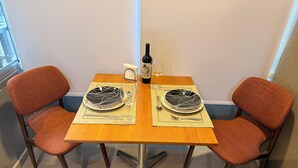 Una mesa de comedor con dos sillas, una botella y un vaso.