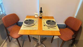 Une table à manger avec deux chaises, une bouteille et un verre.