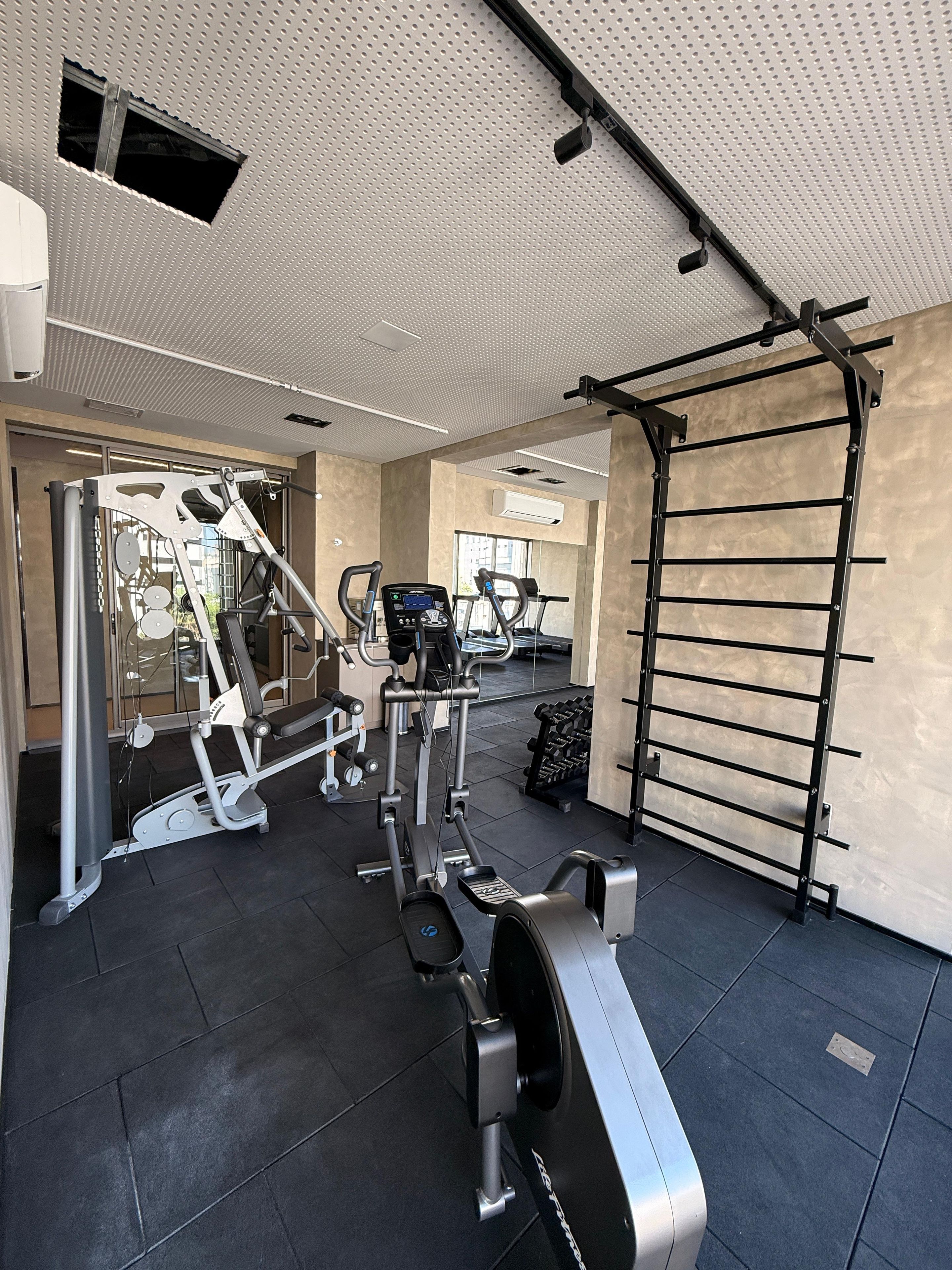Academia com diversos equipamentos de exercício, incluindo esteiras e aparelhos de musculação.
